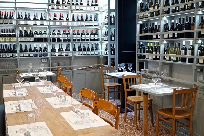 scaffali vino e tavoli per mangiare