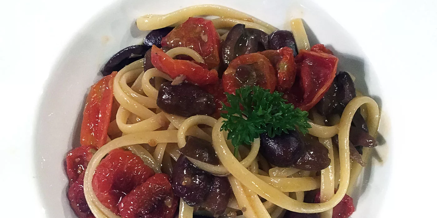 piatto di pasta con olive e pomodori