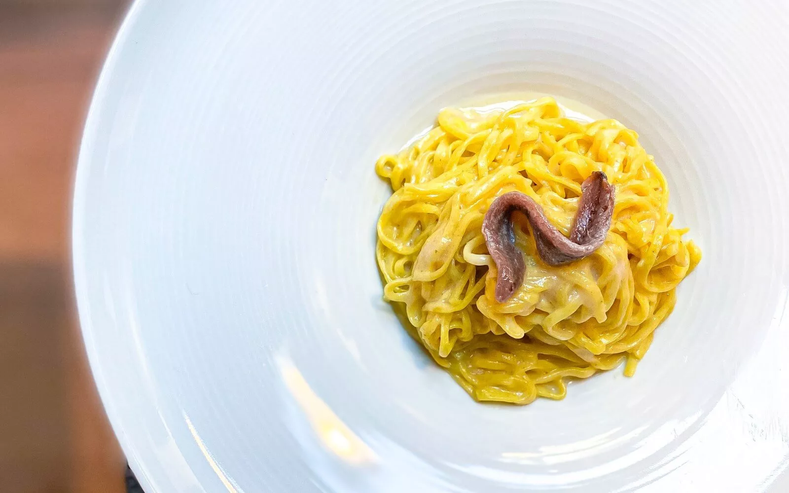 piatto bianco con taglioni, burro e alici
